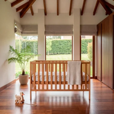 Cuna Aevum en madera de roble natural en una habitación de bebé iluminada