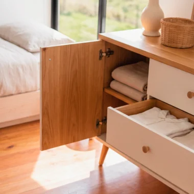 Cómoda de bebé Mireille con puerta y cajón abiertos mostrando el almacenamiento interior