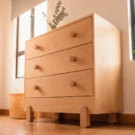 Cómoda infantil Liselle de tres cajones en madera de roble con patas c