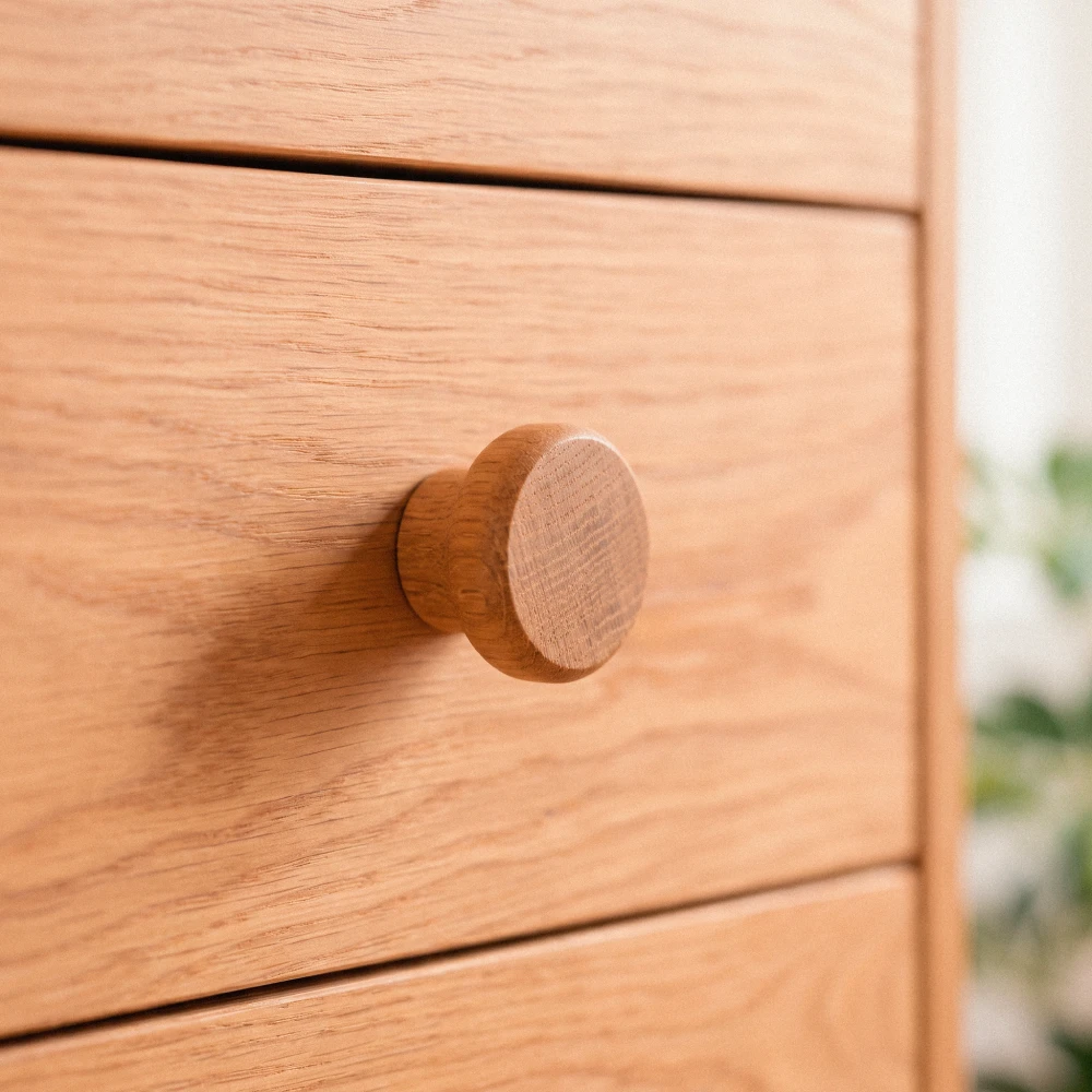 Detalle del tirador redondo torneado en madera de roble de la cómoda L Detalle del tirador redondo torneado en madera de roble de la cómoda Liselle